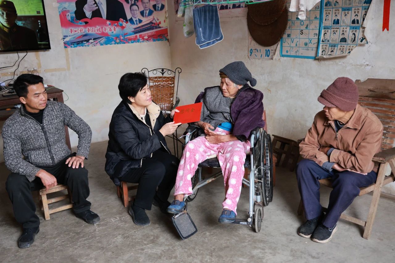 图为广西残联党员干部与困难重度残疾人结对帮扶